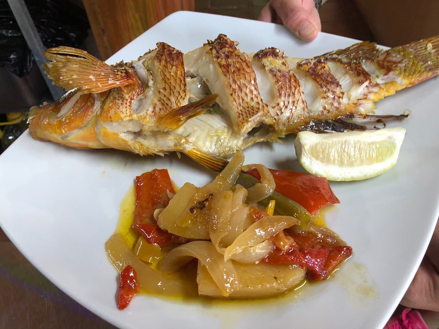 Pescado local recién cocinado y servido en mesa